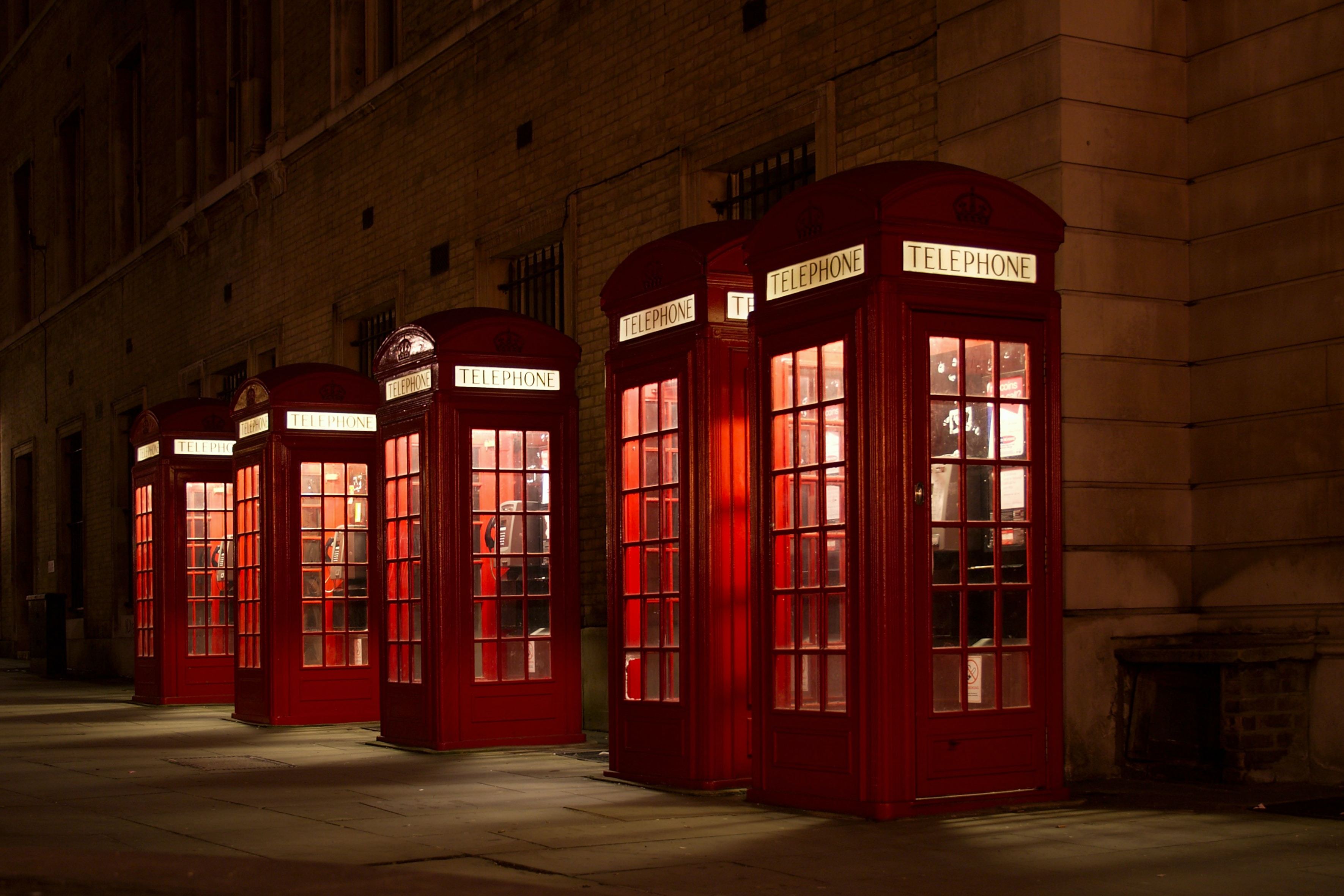 Photo of a line of British phone booths at night